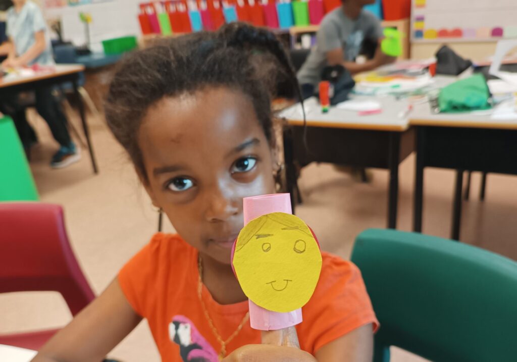 Élève montrant la marionnette qu'elle a créé dans un contexte d'art et interdisciplinarité à l'école.